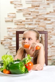 Little girl eat vegetables at room
