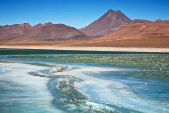 view on frozen lagoon Quepiaco and volcano Acamarachi in Atacama desert, Chile