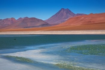 view on frozen lagoon Quepiaco and volcano Acamarachi in Atacama desert, Chile