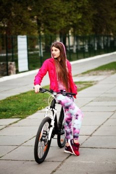 Happy hipster girl with bike in the city. Toned and filtered photo. Modern youth lifestyle concept.