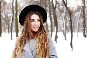 fashion portrait of young romantic dreaming hipster girl in grey coat and black hat. 