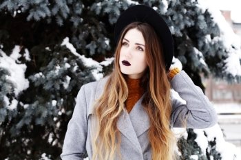 fashion portrait of young romantic dreaming hipster girl in grey coat and black hat. 