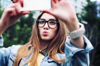 Pretty young female tourist makes selfie. Beautiful urban woman taking picture of herself.