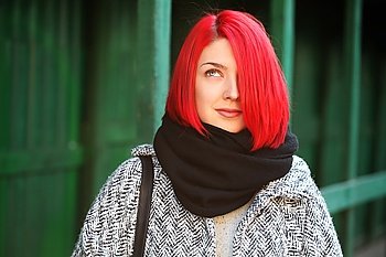 Beautiful red haired woman posing outdoors. Street style.