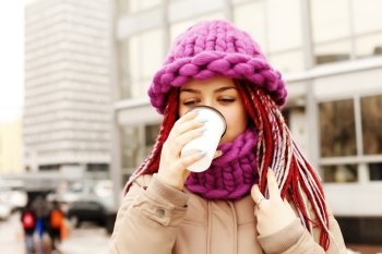 Girl outdoor holding a cup of coffee during a cold weather