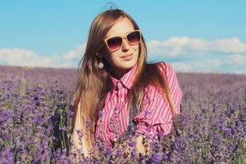 Young pretty woman posing outdoor in the lavender fields. Bohemian style. Blowing long hair. Fashion shooting. Boho-chic. 