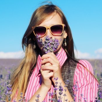 Young pretty woman posing outdoor in the lavender fields. Bohemian style. Blowing long hair. Fashion shooting. Boho-chic. 