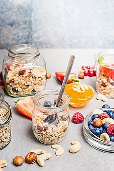 Breakfast in jar, preparation with fresh berries,nuts and muesli. Healthy and Clean food concept.