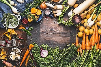 Vegetables cooking ingredients for tasty vegetarian dishes. Carrot , potato , onion , mushrooms , garlic , thyme , parsley on dark rustic wooden background, frame