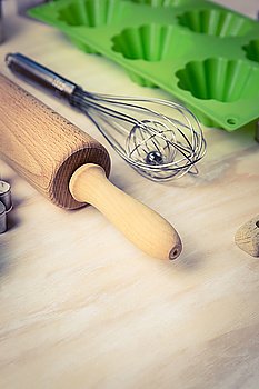 Tools for baking of muffins or cupcakes on wooden background. Retro toned
