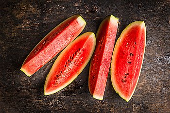 slices of watermelon on rustic wooden background, top view