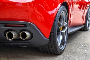 Double exhaust pipes of a modern red sports car. Car exterior details. 
