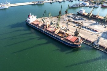 Aerial view from a drone of a large ship loading grain for export. Water transport 