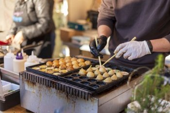 Process of cooking takoyaki balls. Japanese snacks and street food at the festival
