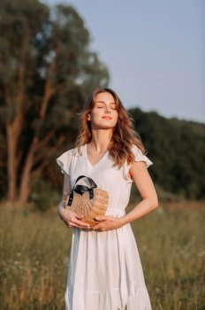 Its likely a scene from a wedding or a summery outdoor event.. A woman smiling while holding a turtle outdoors in a grassy field under a clear sky 5645.