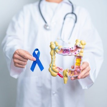 Doctor holding Blue ribbon with human Colon anatomy model. March Colorectal Cancer Awareness month, Colonic disease, Large Intestine, Ulcerative colitis, Digestive system and Health concept