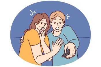 Frightened man and woman with TV remote control are shocked after watching scary movie with murders or monsters. Shocked couple gets scared while watching news on TV because of depressing forecasts. Frightened man and woman with TV remote control are shocked after watching scary movie