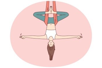 Woman doing aerial yoga hangs upside down in hammock and keeps balance with arms at sides. Girl during workout in yoga studio meditates enjoying practices that cause harmony and get rid of nerves. Woman doing aerial yoga hangs upside down in hammock and keeps balance with arms at sides