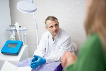 A male doctor is talking and consulting with his patient