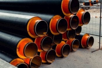 Group of new metal industrial pipes for water outside, pipeline for urban construction, sewage or heat supply. Selective focus on the foreground.