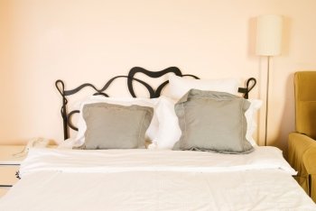 Pillows and bed in bedroom with white wall