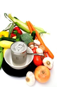 Vegetables for vegetable soup including carrot, bell pepper, broccoli, mushroom, squash, garlic, tomatoes or a can of store bought canned soup served in a white bowl on a black saucer. Fresh Or Canned