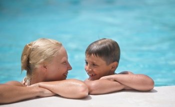 happy boy and mom in the swimming pool