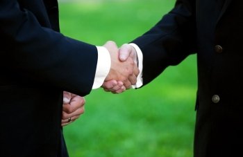 Two gentleman shaking hands.  A gesture commonly done upon meeting, greeting, parting, offering congratulations, expressing gratitude, or completing an agreement.