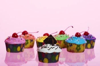 A variety of fancy cupcakes shot using pink gels.