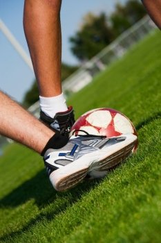 Two men’s feet fighting for the soccer ball.