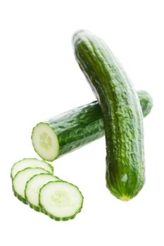 Two fresh English cucumbers, with one sliced.  Shot on white background.
