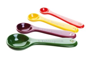 Ceramic measuring spoons in four bright colors.  Shot on white background.