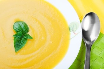 Creamy, butter yellow, Butternut Squash soup with herb garnish.