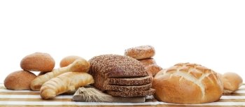 A panorama of assorted baked breads.  Shot on white background.