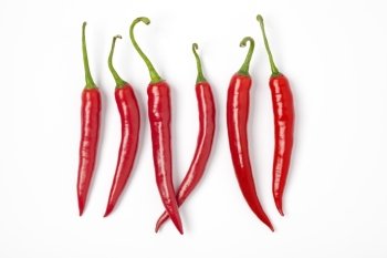 Six Red Hot Chili Peppers In A Row On White Background