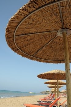 Straw beach umbrellas and sandy beach Kalamaki at Zakynthos, Greece.