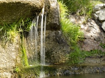 waterfall between rocks with vegetation on the sides