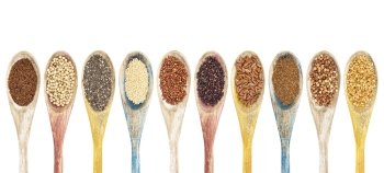 a collection of gluten free grains and seeds on isolated wooden spoons - kaniwa, sorghum, chia, amaranth,red quinoa, black quinoa, brown rice, teff, buckwheat, gold flax (from left to right)