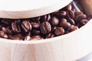 Coffee beans in a wooden barrel, close up, horizontal image