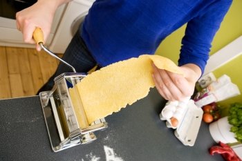 A young female makes pasta at home in the kicthen