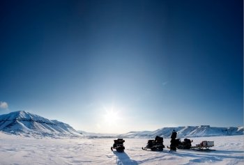 Three snowmobiles on a beautiful winter landscape