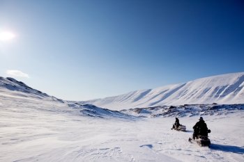 Two snowmobiles on a barren winter landscape, Svalbard Norway