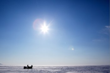 Two snowmobiles on a frozen lake in winter