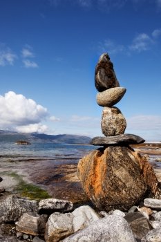 A rock stacking sculpture statue on a Norwegian landscape