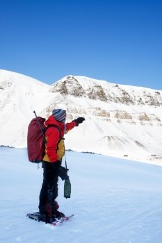 An adventure guide on snowshoes against a winter wilderness landscape
