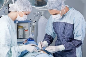 Medical professionals carrying on surgery on patient in operation theatre