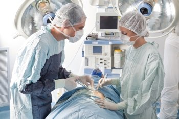 Surgeons performing operation on patient in hospital