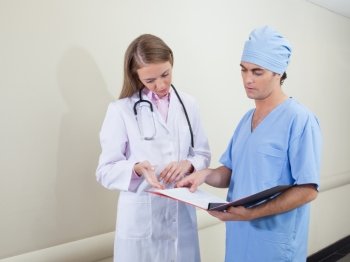 Doctor and nurse studying information from document