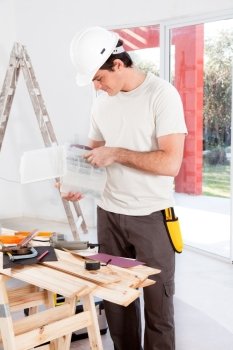 A man looking for a screw, doing home improvements