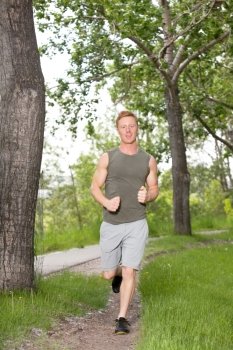 Portrait of a young man running in a park